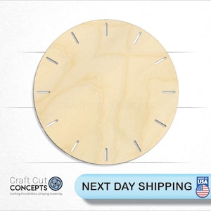 May include: A plain, round, wooden clock face with 12 evenly spaced markings for the hours. The clock face is made of light-colored wood.