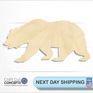 May include: A wooden cutout of a bear in a walking pose. The bear is light brown and has a simple design.