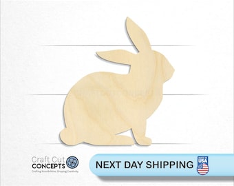 May include: A wooden cutout of a rabbit in a sitting position. The rabbit is made of unfinished wood and is ready to be painted or stained.