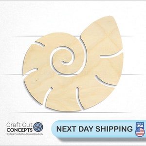 May include: A wooden cutout of a seashell in a light brown color. The seashell is in a spiral shape with a smooth surface.