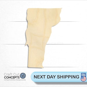 May include: A wooden cutout of the state of Vermont. The cutout is unpainted and has a natural wood color. The cutout is on a white background.