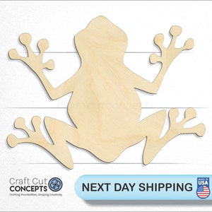 May include: Unpainted wooden frog cutout. The frog is in a sitting position with its legs outstretched. The cutout is made of unfinished wood and is ready to be painted or decorated.