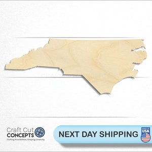 May include: A wooden cutout of the state of North Carolina. The cutout is light brown and has a smooth surface. The cutout is on a white background.