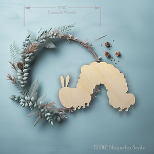 Caterpillar shape wood craft shape on a wreath showing scale.
