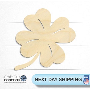 May include: A wooden cutout of a four-leaf clover, a symbol of good luck. The clover is light brown and has a simple, classic design.