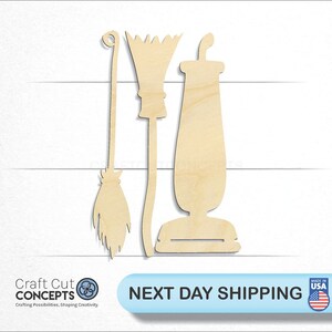 May include: Three wooden cutouts of Halloween-themed items: a broom, a witch's broom, and a vacuum cleaner. The items are made of light-colored wood and are arranged against a white background. The text "Craft Cut Concepts" and "NEXT DAY SHIPPING" are also visible.
