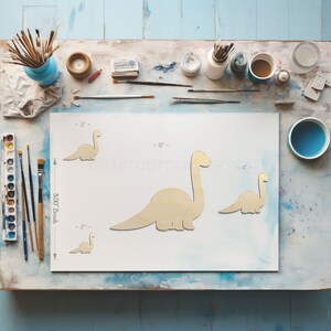 Baby Dinosaur Brontosaurus Shape Craft blanks next to paint brush showing scale