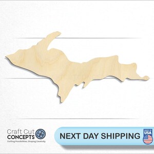 May include: A wooden cutout of the Upper Peninsula of Michigan. The cutout is made of natural wood and has a light brown color. The cutout is a popular craft item for home decor and gifts.