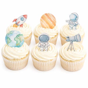 Puede incluir: Seis cupcakes con glaseado blanco y decoraciones temáticas espaciales. Los adornos incluyen un cohete, un planeta, un astronauta, un telescopio y un globo terráqueo. Los cupcakes están dispuestos sobre una superficie blanca, ideales para una fiesta o evento temático espacial.