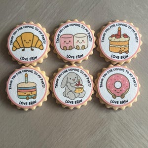 Peut inclure: Six biscuits ronds avec des dessins animés, dont un croissant, des guimauves, un gâteau et un donut. Chaque biscuit porte l'inscription "THANK YOU FOR COMING TO MY PARTY" et "LOVE ERIN".