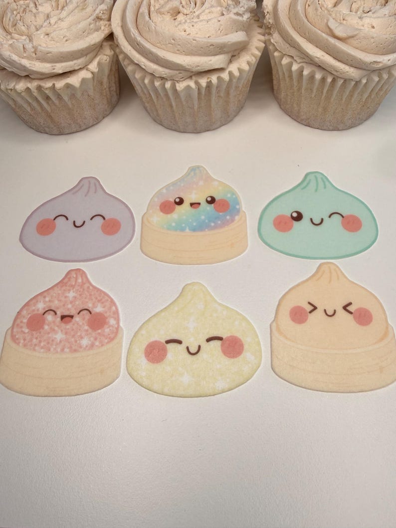 May include: Three cupcakes with beige frosting are positioned above six flat, sticker-like illustrations of dumplings. The dumplings feature various pastel colors, glittery textures, and simple, happy facial expressions with rosy cheeks.
