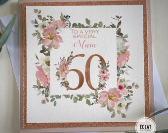 May include: A white card with a rose gold border and a floral design. The card says "To a very special Mum 60".