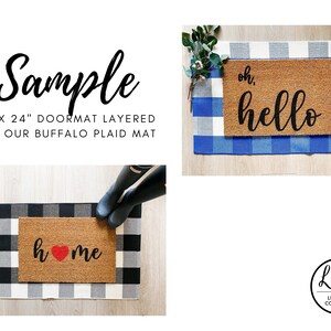 May include: Two doormats with black lettering on a brown coir background. The first doormat says "oh, hello" and the second doormat says "home" with a red heart. Both doormats are layered on top of a black and white buffalo plaid rug.