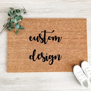 May include: A brown coir doormat with the text "custom design" in black lettering.