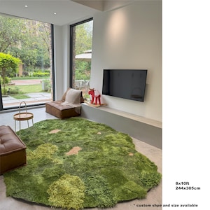 May include: A green, shaggy rug with a landscape design, approximately 8x10 feet. The rug features raised areas and lighter patches, resembling a grassy field. The rug is in a modern living room setting.