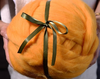 May include: A large ball of orange wool yarn tied with a green ribbon.