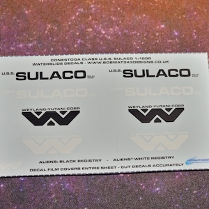 May include: Waterslide decals for a 1:1000 scale model of the U.S.S. Sulaco spacecraft from the film Aliens. The decals feature the Weyland-Yutani Corporation logo and the text "U.S.S. Sulaco". The decals are for a black registry and a white registry.