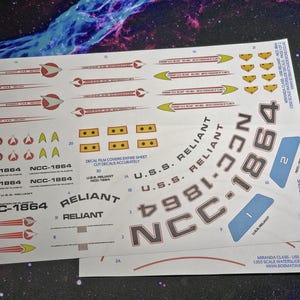 Puede incluir: Una hoja de calcomanías de agua para un modelo a escala 1:350 de la nave espacial USS Reliant de Star Trek. Las calcomanías incluyen el número de registro de la nave NCC-1864, el nombre "Reliant" y varias otras marcas. Las calcomanías están impresas en una película transparente y están diseñadas para ser recortadas y aplicadas al modelo.