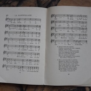May include: A vintage sheet music book with the title "La Marseillaise" printed on the cover. The book is open to a page with musical notation and lyrics in French. The lyrics include the words "Amour sacr&eacute; de la patrie" and "Aux armes, Citoyens!"