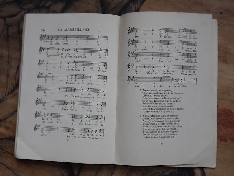 May include: A vintage sheet music book with the title "La Marseillaise" printed on the cover. The book is open to a page with musical notation and lyrics in French. The lyrics include the words "Amour sacr&eacute; de la patrie" and "Aux armes, Citoyens!"