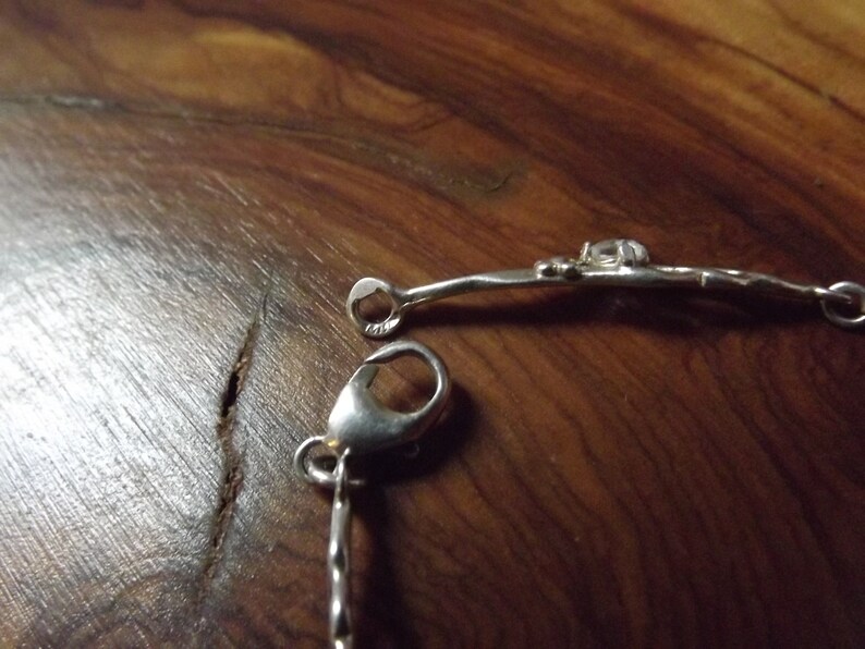Peut inclure: Bracelet en argent avec une cha&icirc;ne d&eacute;licate et une fermeture &agrave; fermoir.