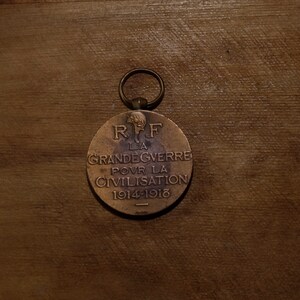 May include: A bronze medal with a loop for hanging. The front of the medal has the text "R.F. LA GRANDE GUERRE POUR LA CIVILISATION 1914-1918".