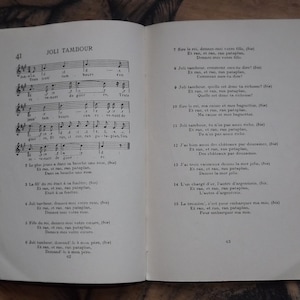 May include: A vintage French children's book titled "Joli Tambour" with a musical score and lyrics. The book is open to pages 41 and 43, showing the lyrics for the song "Joli Tambour".