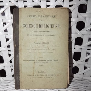 May include: A vintage book titled "Cours Élémentaire de Science Religieuse" by Antoine Guyot. The book is for use by boarding school students and those studying catechism. It was approved by the Bishop of Saint-Dié and published by Librairie Bloud et Barral in Paris.