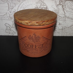 Puede incluir: Una jarra de café de terracota con tapa de madera. La jarra tiene una etiqueta que dice "COFFEE Royal Staffordshire Ware".