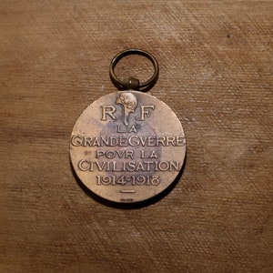 May include: A bronze medal with a loop for hanging. The front of the medal features the text "R.F. LA GRANDE GUERRE POUR LA CIVILISATION 1914-1918".