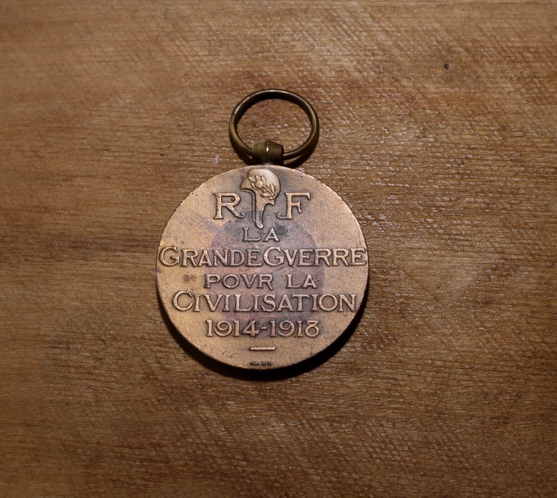 May include: A bronze medal with a loop for hanging. The front of the medal features the text "R.F. LA GRANDE GUERRE POUR LA CIVILISATION 1914-1918".
