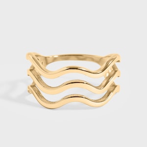 May include: Gold ring with three wavy bands.