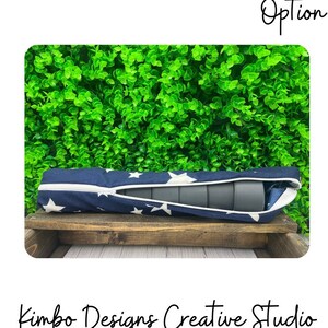 May include: A blue and white fabric storage case with white stars and a zipper closure. The case is filled with rolled up gray foam cylinders. The case is sitting on a wooden shelf in front of a green wall.