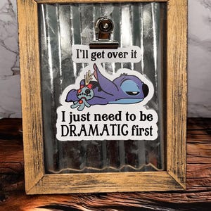 May include: A framed print with a blue and purple cartoon character with the text "I'll get over it I just need to be DRAMATIC first".