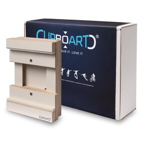 Könnte beinhalten: Ein hellbeige Holz-Klemmbrett mit passender Box. Das Klemmbrett hat ein einzigartiges Design mit mehreren horizontalen Leisten. Die Box ist marineblau mit dem Text "CLIPBOARD ART" und dem Slogan "HAVE IT. LOVE IT."