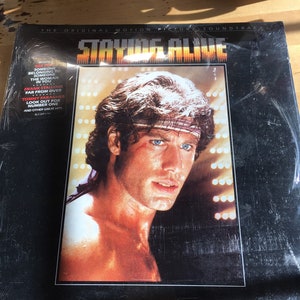 Staying Alive. The Original motion picture soundtrack.  Unopened in the same package Flashdance, the original motion picture soundtrack.