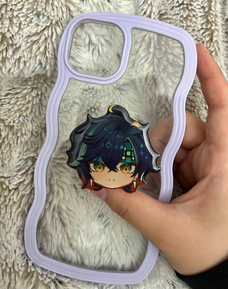 May include: A clear phone case with a wavy lavender border and a central circular accessory featuring a stylized anime character head with dark blue hair, green eyes, and a green patterned headband, designed for a mobile device.