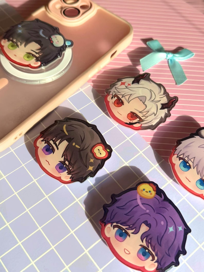 May include: A collection of colorful anime-style character phone grips. Each grip features a unique character design with vibrant hair and eyes. The grips are in various colors, including purple, black, and white, with cute accessories.