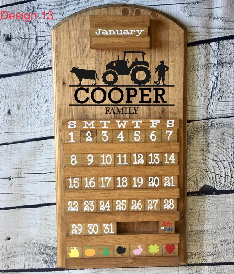 May include: A wooden calendar with a farmhouse theme. The calendar features a tractor, a cow, and a farmer. The calendar is personalized with the name "COOPER FAMILY" and the month of January. The calendar has a slot for each day of the month and includes a small wooden block for each day. The calendar also has a small wooden block for the 4th of July.