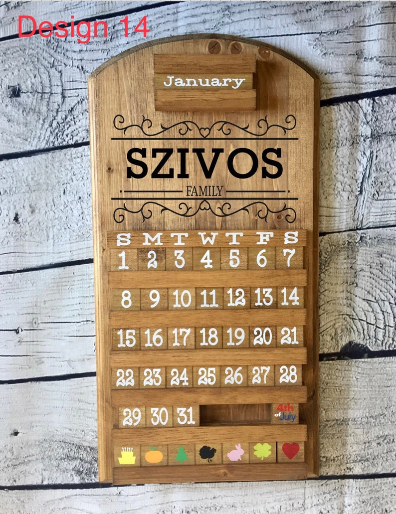May include: A wooden calendar with the word "January" at the top, the name "SZIVOS FAMILY" in the center, and the days of the week and numbers 1 through 31 below. The calendar has a small wooden shelf at the bottom with colorful wooden blocks.