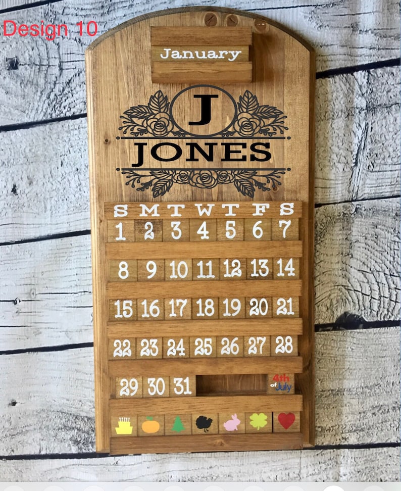 May include: A wooden calendar with a floral design and the name "JONES" in black lettering. The calendar is for January and has a small wooden block with the text "4th of July" on it.