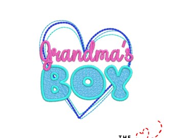 May include: A blue and pink embroidered design that says "Grandma's Boy" inside a heart shape. The text is in a playful font, with a light blue outline. The design is on a white background.