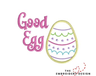 May include: An embroidered design featuring the words "Good Egg" in pink script, next to a decorated Easter egg. The egg has a yellow outline, with pink, blue, and green decorative elements. The design includes the text "THE EMBROIDERY DESIGN SPOT".