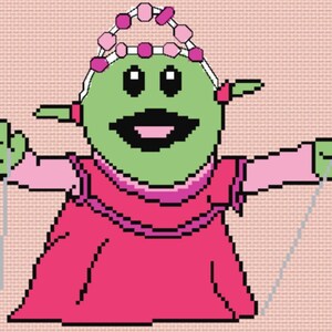 May include: A green alien wearing a pink dress and a pink beaded crown is holding two strings in its hands. The alien has a big smile and is looking happy.