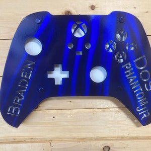 May include: A blue and black metal Xbox controller wall decor with the names "Braden" and "DOS PHANTOM JR" cut out.