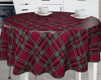 May include: Red and green plaid tablecloth with a scalloped edge. The tablecloth is laid on a round table with two white cups and saucers on the table.