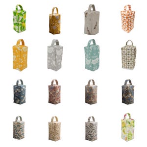 May include: A collection of sixteen rectangular fabric doorstops, each featuring a top handle and a variety of printed patterns including botanical, floral, geometric, and animal motifs in diverse colours such as green, yellow, blue, and beige.