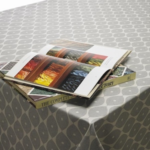 May include: A grey and white patterned tablecloth with a book titled "The Complete S...ctory" on top. The book is open and shows a colourful display of yarn.