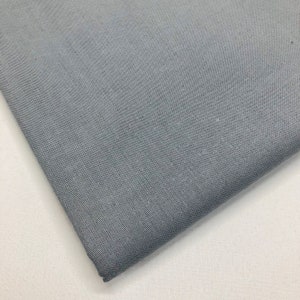 May include: A close-up of a piece of gray fabric with a subtle texture. The fabric is folded over on itself, showing the underside.