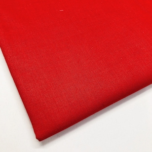May include: A solid red fabric swatch. The fabric has a smooth, even texture.